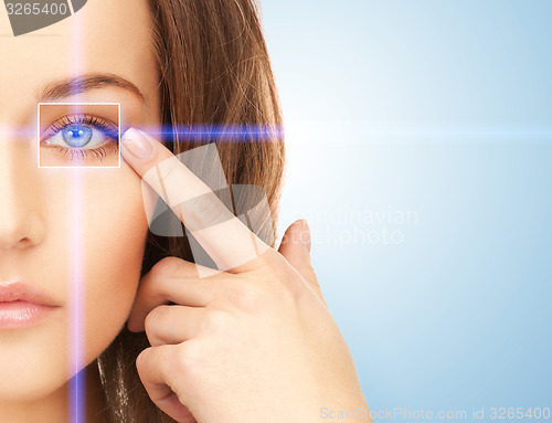 Image of beautiful woman pointing to eye