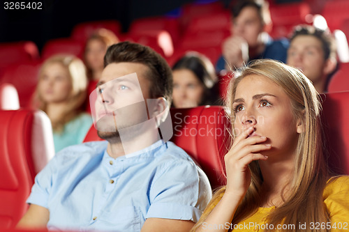 Image of happy friends watching horror movie in theater