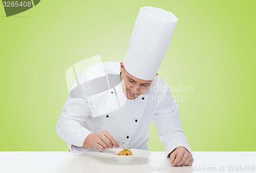 Image of happy male chef cook decorating dish
