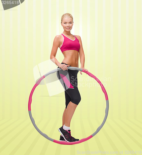 Image of young sporty woman with hula hoop