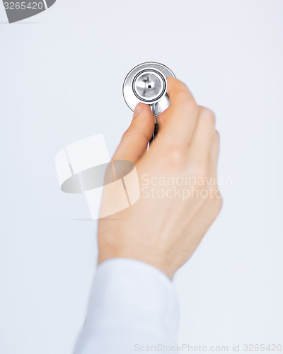 Image of doctor hand with stethoscope listening somebody