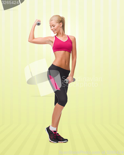 Image of young sporty woman with dumbbells