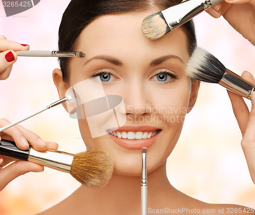 Image of happy woman applying professional make-up