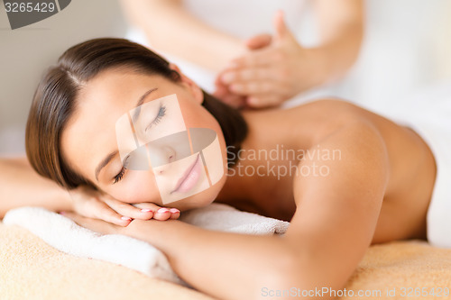 Image of beautiful woman in spa salon getting massage