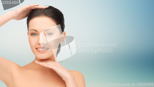 Image of beautiful young woman touching her face and chin