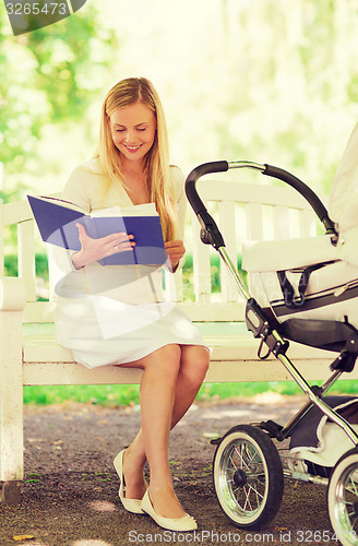 Image of happy mother with book and stroller in park