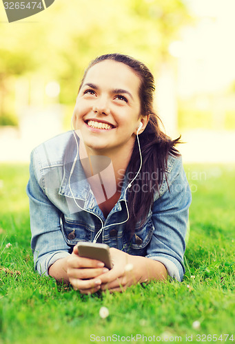 Image of smiling young girl with smartphone and earphones
