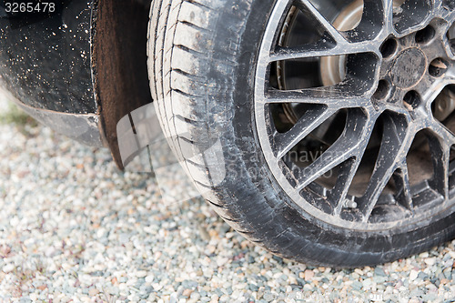 Image of close up of dirty car wheel on ground