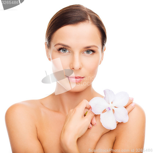 Image of relaxed woman with orhid flower