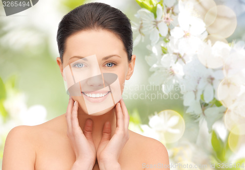 Image of beautiful young woman touching her face and neck