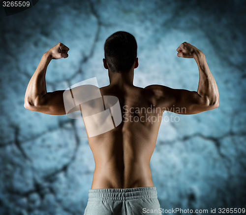 Image of young man or bodybuilder showing biceps