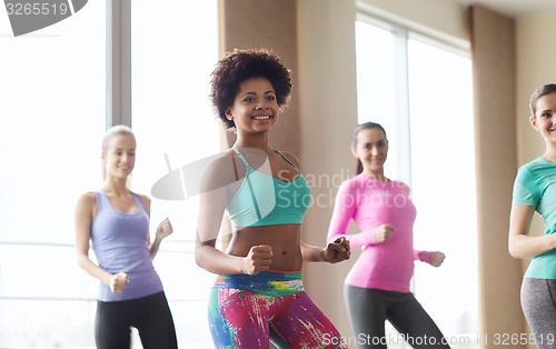 Image of group of smiling people dancing in gym or studio