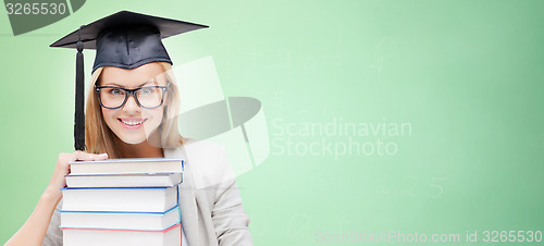 Image of happy student in mortar board cap with books