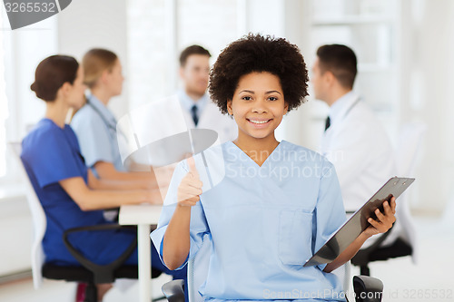 Image of happy doctor over group of medics at hospital