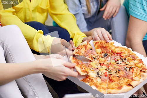 Image of close up of happy friends eating pizza at home