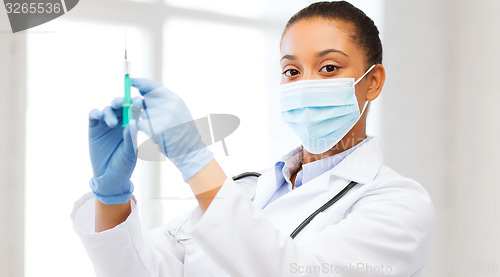 Image of african doctor holding syringe with injection