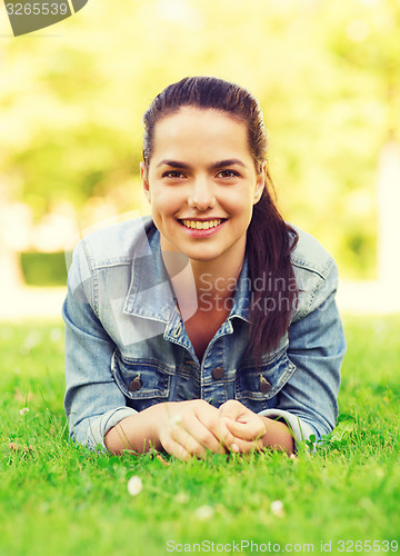 Image of smiling young girl lying on grass