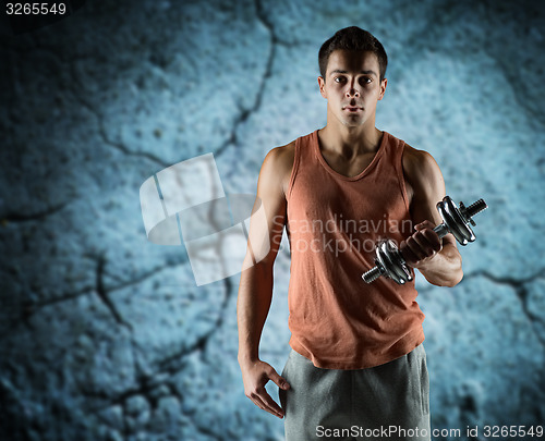 Image of young man with dumbbell flexing biceps