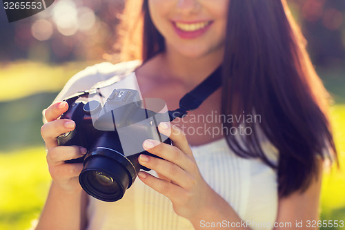 Image of close up of young girl with photo camera outdoors