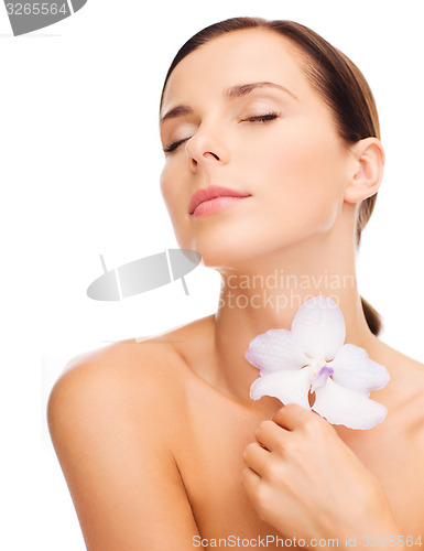 Image of relaxed woman with orhid flower