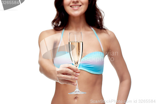 Image of happy young woman in swimsuit drinking champagne