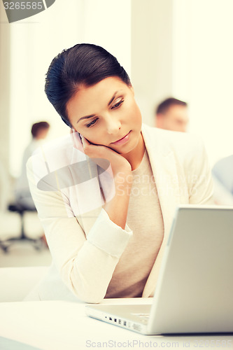 Image of businesswoman with laptop computer at work