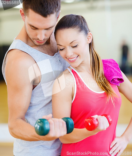 Image of two smiling people working out with dumbbells