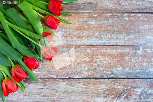 Image of close up of red tulips on wooden background