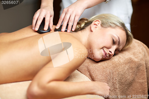 Image of close up of woman having hot stone massage in spa