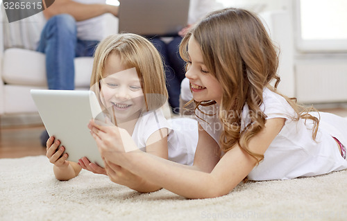 Image of happy little girls with tablet pc computer at home