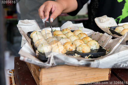 Image of close up of cook hands with meatballs at street