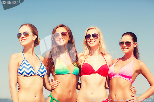 Image of group of smiling young women on beach