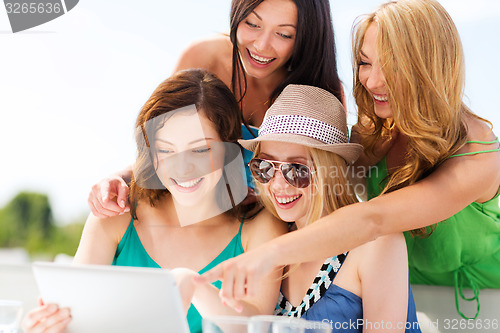 Image of girls looking at tablet pc in cafe