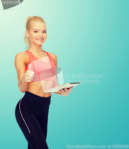 Image of smiling sporty woman with tablet pc computer