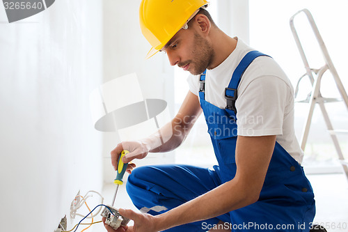 Image of builder with tablet pc and equipment indoors