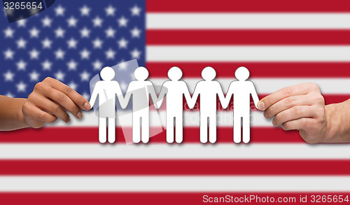 Image of hands holding people pictogram over american flag