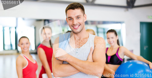 Image of smiling man standing in front of the group in gym