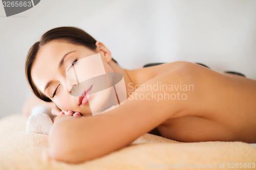 Image of beautiful woman in spa salon with hot stones