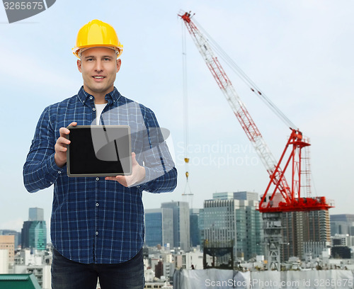 Image of smiling male builder in helmet with tablet pc