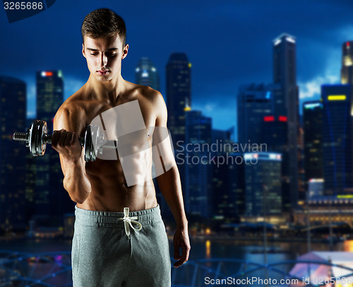 Image of young man with dumbbell flexing biceps