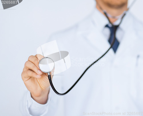 Image of doctor hand with stethoscope listening something