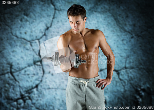 Image of young man with dumbbell flexing biceps