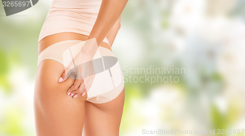 Image of close up of woman in underwear touching buttock