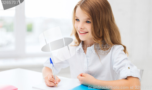 Image of student girl writing in notebook at school