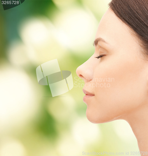 Image of beautiful young woman face over green background