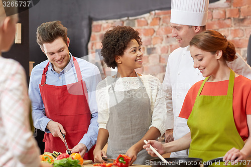 Image of happy friends and chef cook cooking in kitchen