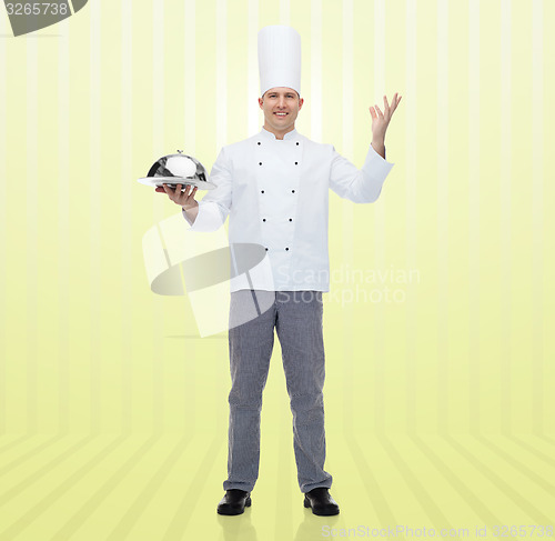 Image of happy male chef cook holding cloche