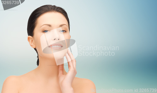 Image of beautiful young woman touching her face