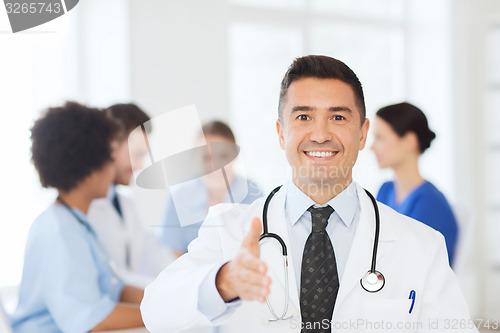 Image of happy doctor over group of medics at hospital