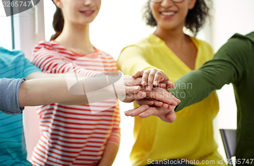 Image of close up of students or friends with hands on top